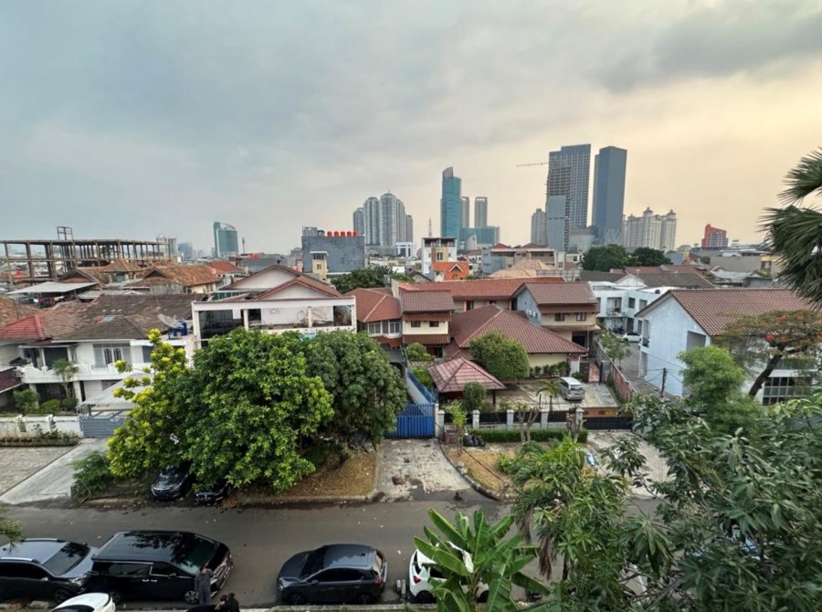 曇り空のインドネシア。奥は高層ビル群があり、手前にはコスと呼ばれるインドネシア特有の住居が並ぶ